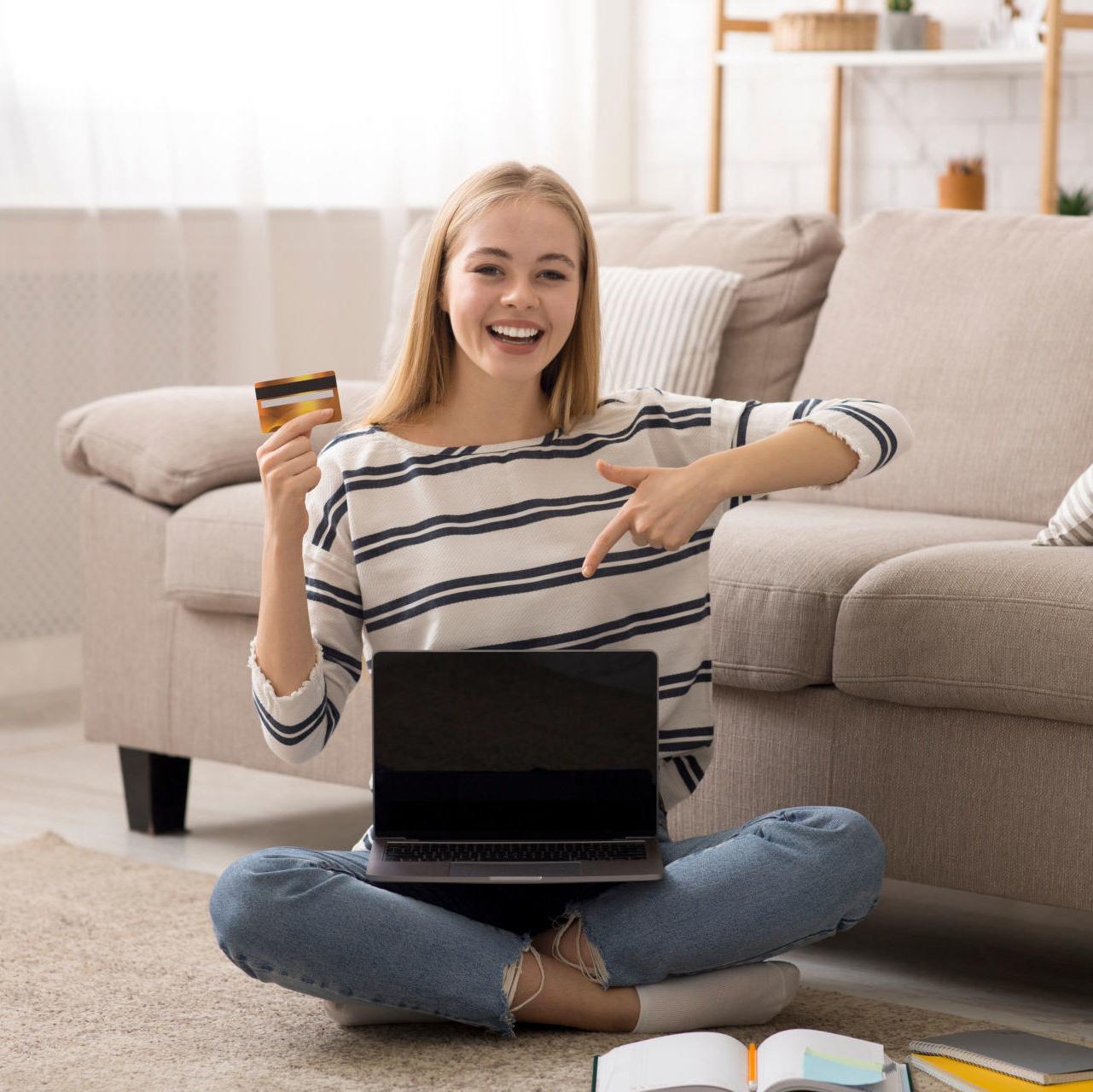 a young woman smiles, excited about learning how to get a student credit card for the first time